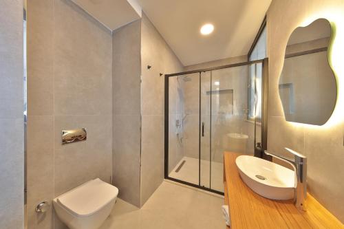 a bathroom with a toilet and a sink and a shower at Lyxos Hotel in Kas