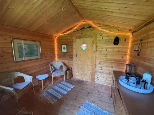 a room in a wooden cabin with a table and chairs at Mistel in Filipstad