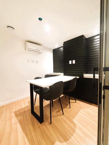 a dining room with a white table and black cabinets at UniHome Niteroi by Housi in Niterói
