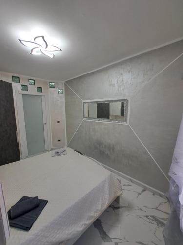 a bedroom with a white bed and a mirror at PRESTIGE House in Nulvi