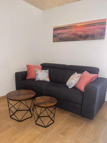 a living room with a black couch and two tables at B&b La Campanella in Palagianello