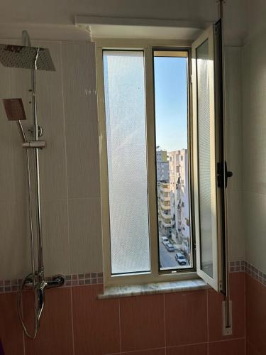 a bathroom with a shower and a window with a view at Leo apartaments with sea view in Durrës