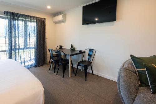 a room with a table and chairs and a couch at Hanmer Springs Gateway Lodge in Hanmer Springs