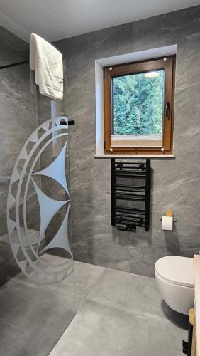 a bathroom with a window and a toilet at Korona Pienin Domki & Apartamenty - Apartament z Sauna i grota solna in Szczawnica