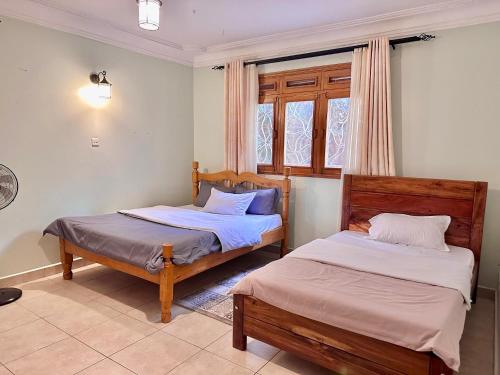 a bedroom with two beds and a window at Green Haven Nsambya, Kampala in Nalakonge