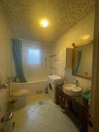 a bathroom with a sink and a toilet and a tub at Soba s pogledom na Dravski Park u Varaždinu in Varaždin