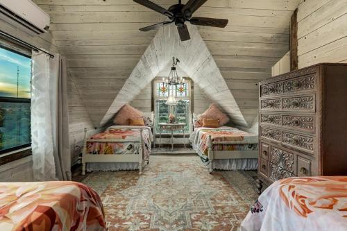 a bedroom with two beds and a ceiling fan at Above All Luxury Lodge in New Braunfels