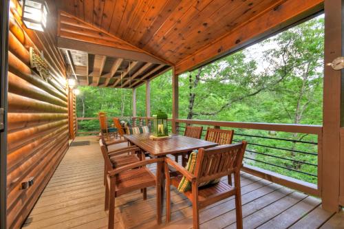 a wooden deck with a table and chairs at A Little Bit of Heaven Swim in the creek soak in the hot tub and relax in comfort in Copperhill