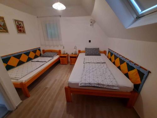 dwa łóżka w małym pokoju z oknem w obiekcie Holiday home in Balatongyörök 42694 w mieście Balatongyörök