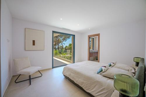une chambre avec un lit, une chaise et une fenêtre dans l'établissement Contemporary Villa with Heated Pool Near Sea, à Saint-Raphaël