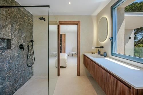 une salle de bain avec baignoire et douche en verre dans l'établissement Contemporary Villa with Heated Pool Near Sea, à Saint-Raphaël