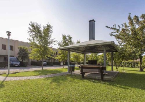 a picnic shelter in a park with a bench at Houses and Apt in Caorle 43917 in Caorle