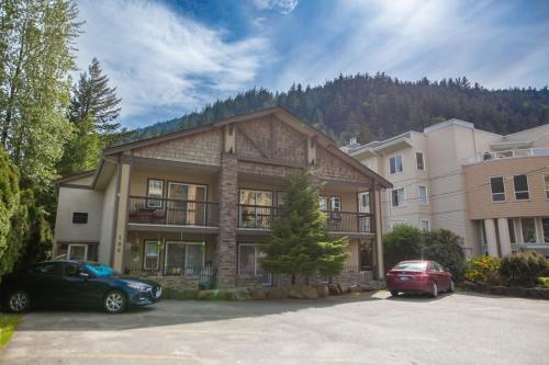 a house with two cars parked in a parking lot at The Riverbend Modern Studio at Harrison Lake in Harrison Hot Springs
