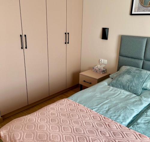 a bedroom with white cabinets and a bed and a table at Apartament SOLMARINA in Iława