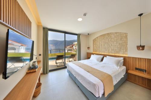 a bedroom with a large bed and a large window at Lyxos Hotel in Kas