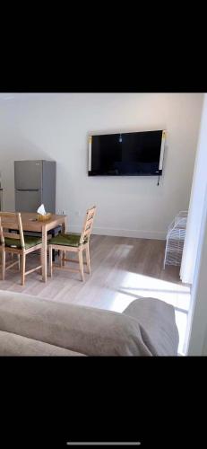 a living room with a table and chairs and a television at Morning Dew105 in Hammonds Plains