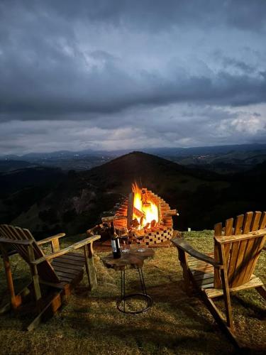 a fire pit sitting on top of a mountain at Chalé Manacá in Sapucaí-Mirim