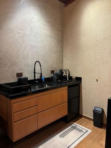 a kitchen with a sink and a counter top at Chalé Manacá in Sapucaí-Mirim