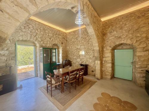 a dining room with a table and a stone wall at Alma Del Monte Stone House w Pool Terrace 