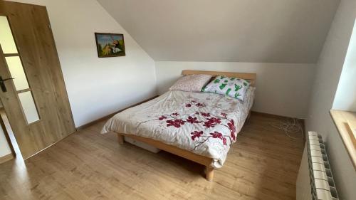 een kleine slaapkamer met een bed op zolder bij Domek w Limanowej in Limanowa