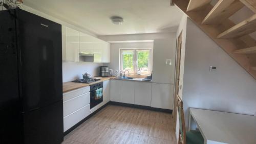een kleine keuken met witte kasten en een raam bij Domek w Limanowej in Limanowa