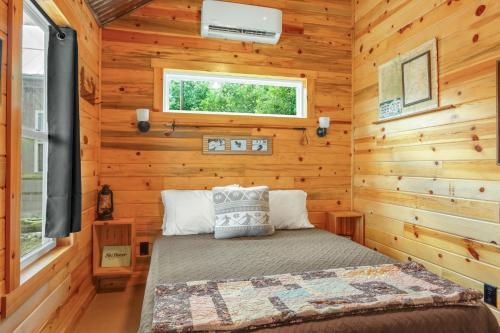 une chambre avec un lit dans une cabane en rondins dans l'établissement RusTx Ranch Unit 3- Colorado, à Wimberley