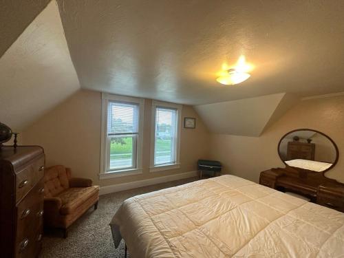 a bedroom with a bed and a dresser and a mirror at Charming Brick House in Little Chute