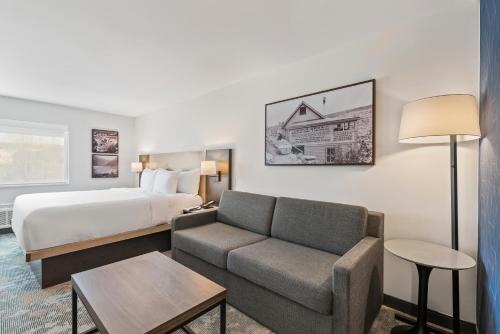 a hotel room with a bed and a couch at The Ellsworth Hotel, an Ascend Collection Hotel in Williams