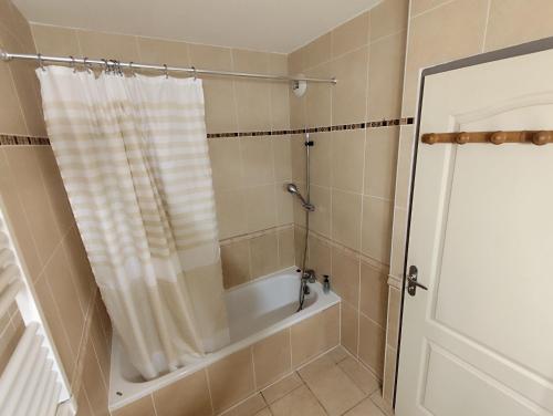 La salle de bains est pourvue d'une baignoire et d'un rideau de douche. dans l'établissement Résidence Les Reflets, à Saint Cyprien Plage