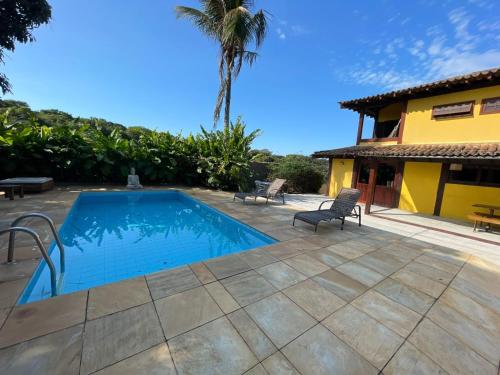 a swimming pool in front of a house at Casa da Tartaruga Búzios in Búzios