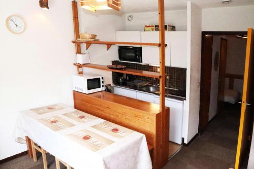 une petite cuisine avec une table et un micro-ondes dans l'établissement Résidence Balcon Orres - 101 balcon des Orres MAE-4134, à Le Mélézet