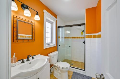 ein orangefarbenes Badezimmer mit Toilette und Dusche in der Unterkunft Waterfront Westhampton Haven Pool and Private Beach in Westhampton Beach