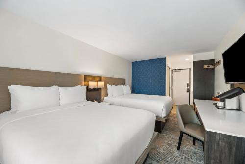 a hotel room with two beds and a desk at The Ellsworth Hotel, an Ascend Collection Hotel in Williams