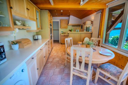 a kitchen and dining room with a table and chairs at Chalet 4 personnes avec sauna in Leysin