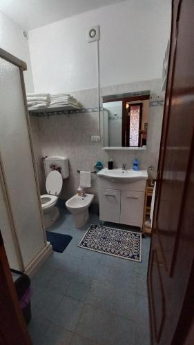 a bathroom with a sink and a toilet and a mirror at Casa Fiorita in Ameglia
