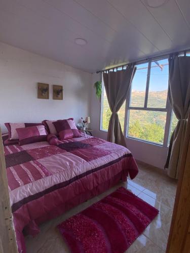 una camera da letto con un letto grande e una grande finestra di Ehden's Skyline a Ehden