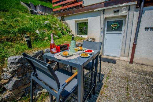 a table with a plate of food and a bottle of wine at Studio loft avec sauna in Leysin