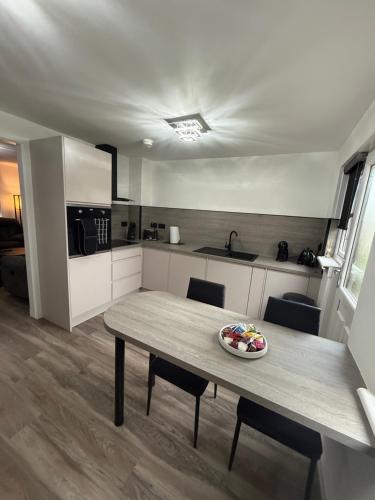 a kitchen with a table with a bowl of fruit on it at Home Comfort Prestwick in Prestwick
