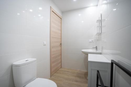 a white bathroom with a toilet and a sink at LETS HOLIDAYS Wake Up by the Sea in Victoria apartment 2 in Tossa de Mar