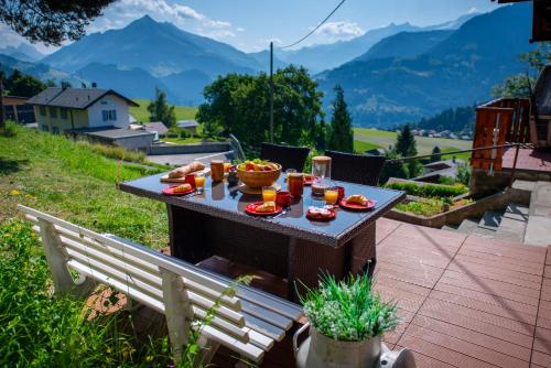 a table with food on it with mountains in the background at Chalet 6 personnes avec sauna in Leysin
