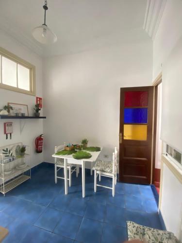 a dining room with a white table and a blue floor at Vivienda Vacacional La Pepita in Santa Cruz de la Palma