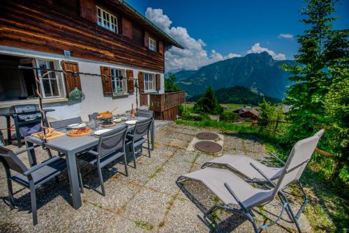 a patio with a table and chairs in front of a house at Chalet 6 personnes avec sauna in Leysin