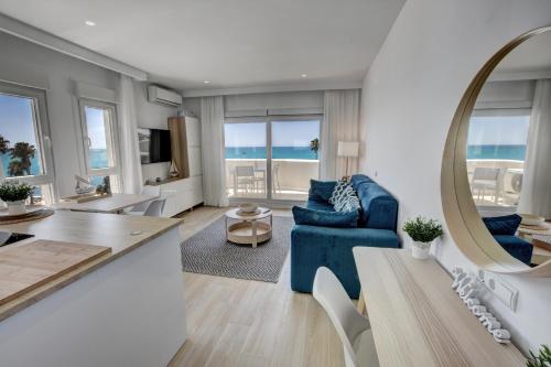 a living room with a blue couch and a mirror at Beachfront Parque Paloma in Benalmádena