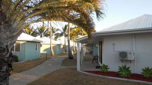 a house that has a tree in front of it at Illawong Beach Resort in Mackay