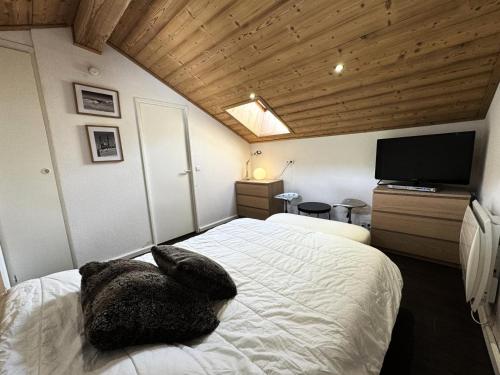 une chambre avec un grand lit et une télévision dans l'établissement Résidence Necou - Duplex de 3 pièces pour 4 personnes avec grand balcon MAE-4081, aux Menuires