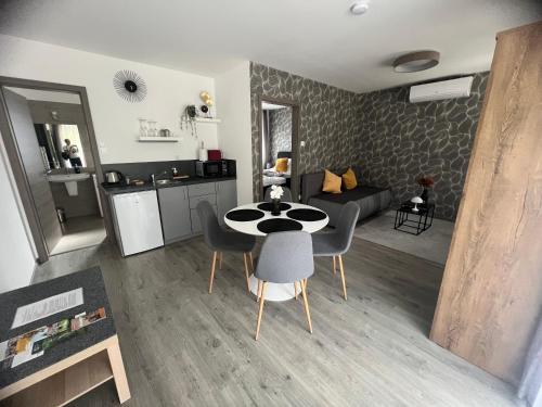a kitchen and a living room with a table and chairs at Sophia Apartman Gödöllő in Gödöllő