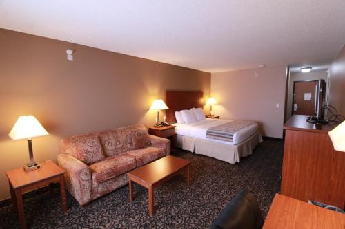 a hotel room with a bed and a couch at Canby Inn and Suites in Canby
