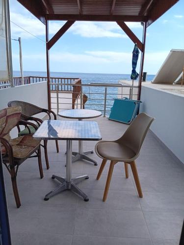 a table and chairs on a balcony with the ocean at Lendas Paradise studio number 1 in Léntas