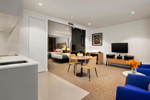 a living room with a blue couch and a table at Quest St Leonards in Sydney