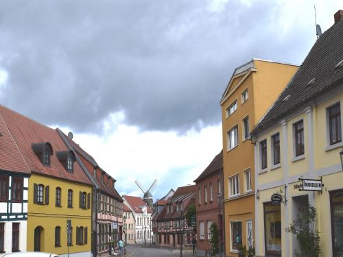 a street in a town with buildings and a windmill at Wohnung in Röbel am Müritzsee in Röbel